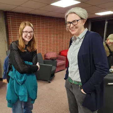 faculty member and student standing and smiling